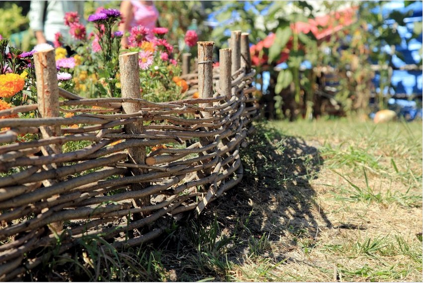 Vízszintes fonott kerítés a virágágyat határolja