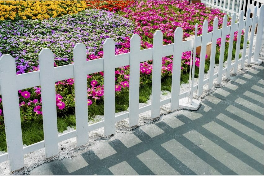 Egy műanyagból készült dekoratív kerítés különleges varázsságot ad a virágoskertnek