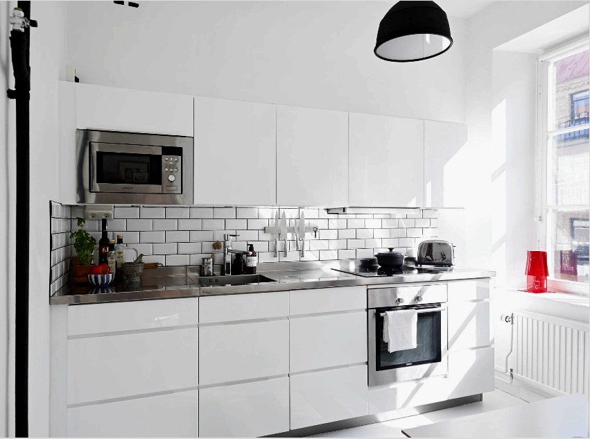 A fehér, fényes konyha vizuálisan kibővíti a helyiséget, tágas és könnyűvé teszi