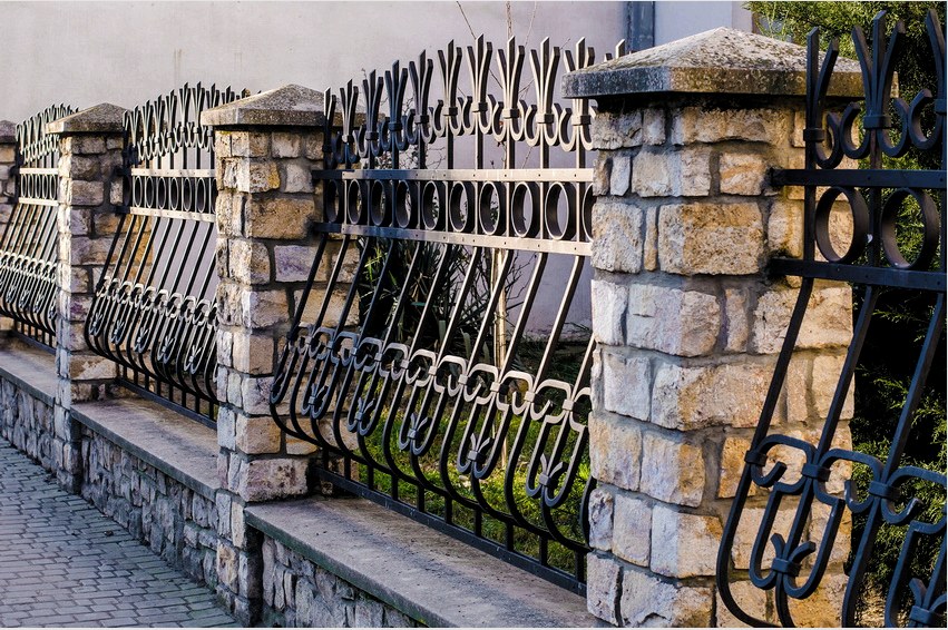A kerítés és a kő alapja kovácsolt részeinek használata - nagyon népszerű lehetőség a kerítéshez