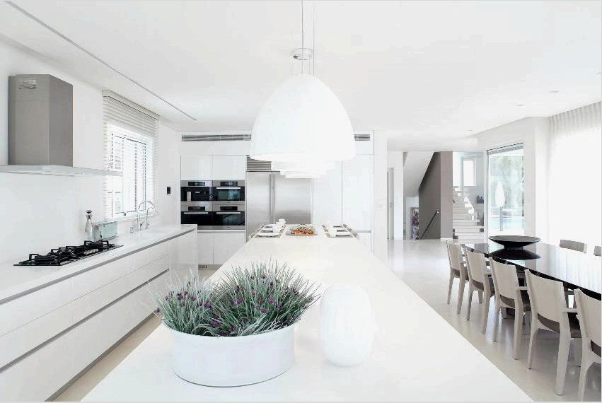 A minimalista stílus a konyha belsejében lehetővé teszi az étkező felszerelését a nappalival, és fény és szín segítségével zónát alakíthat ki.