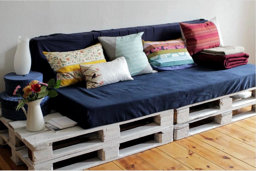Több raklapból és puha párnából egyszerű kanapémodellt készíthet