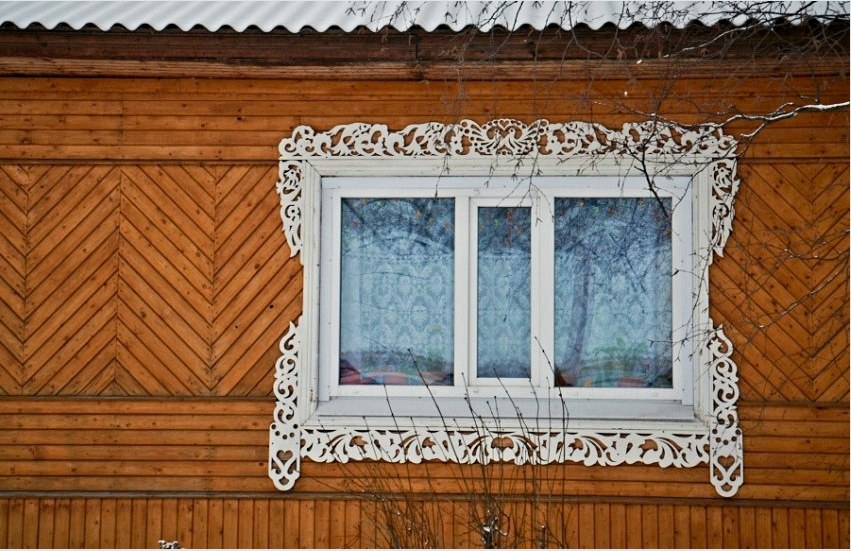Faragott sávok a fából készült ház műanyag ablakain