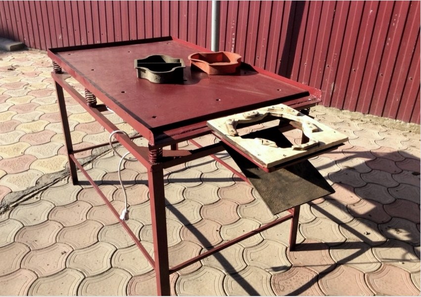 Példa egy vibráló asztal kialakítására fúvókával ellátott útburkoló táblák gyártásához