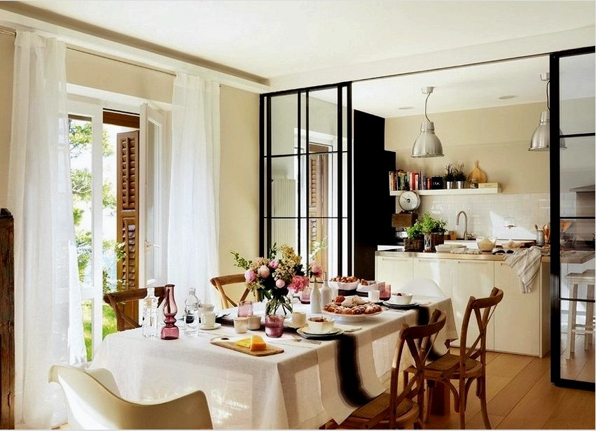 Üvegből és fémből készült csúszó válaszfalat helyeznek el a konyha és az étkező-nappali között
