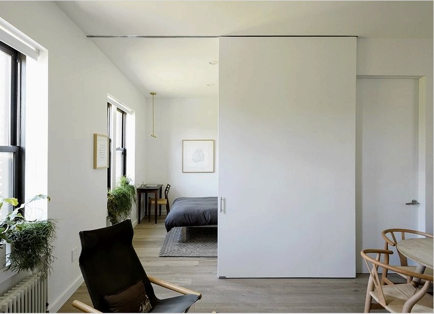 Funkcionális válaszfal, amely osztja a hálószoba és a nappali helyét egy kis városi lakásban