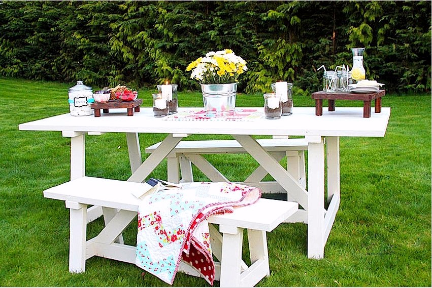 A fehérre festett faasztal és padok hangulatos étkezőt képeznek a kertben