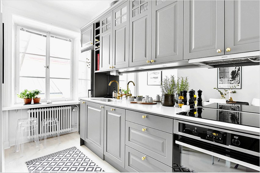 A szürke világos árnyalatai kedvezően néznek ki egy kis konyha belsejében, amelynek mérete vizuálisan megnő