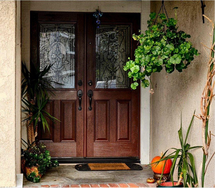 Üveg és dekoratív kovácsbetétekkel rendelkező bejárati ajtók költsége nagyon magas.