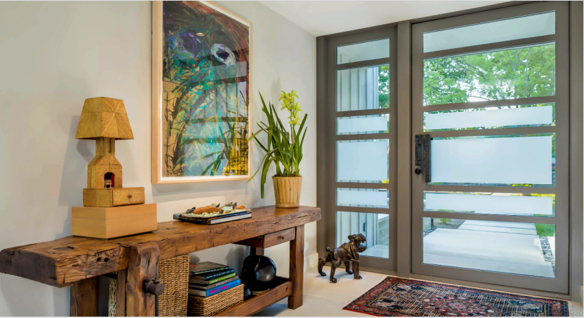 A bejárati ajtó üvegből készült átlátszó felülete felfedi a helyiségek belső megoldásának előnyeit