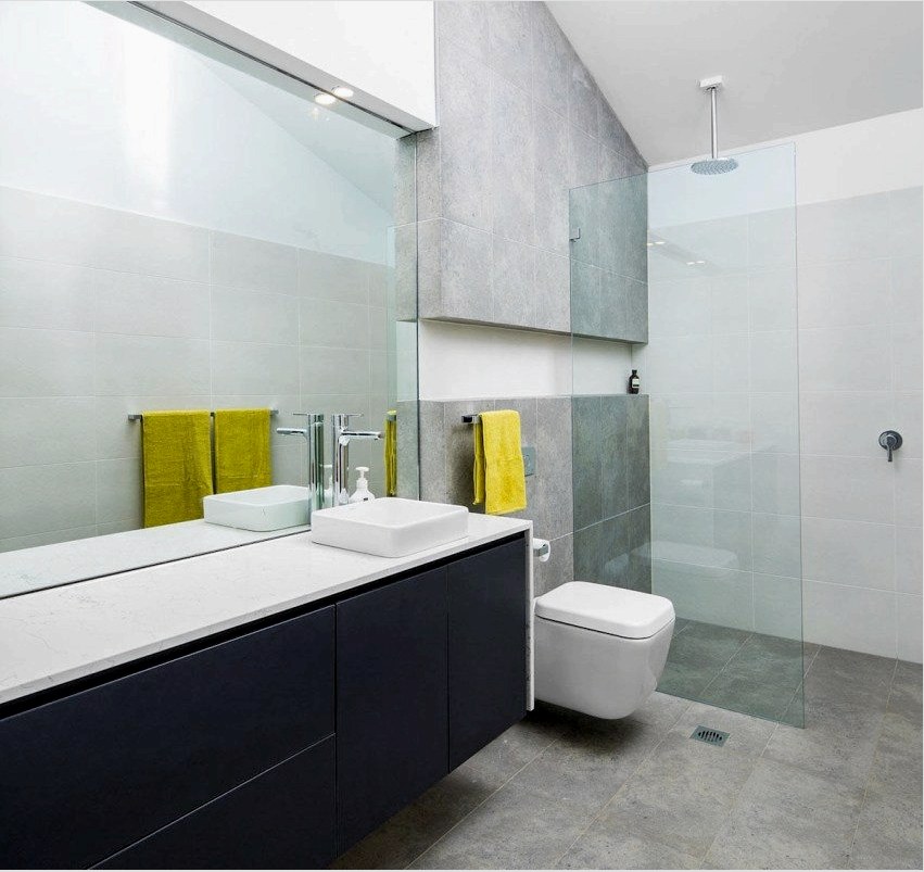 A tükrök és az átlátszó válaszfalak vizuálisan kibővítik a WC-vel kombinált fürdőszobát