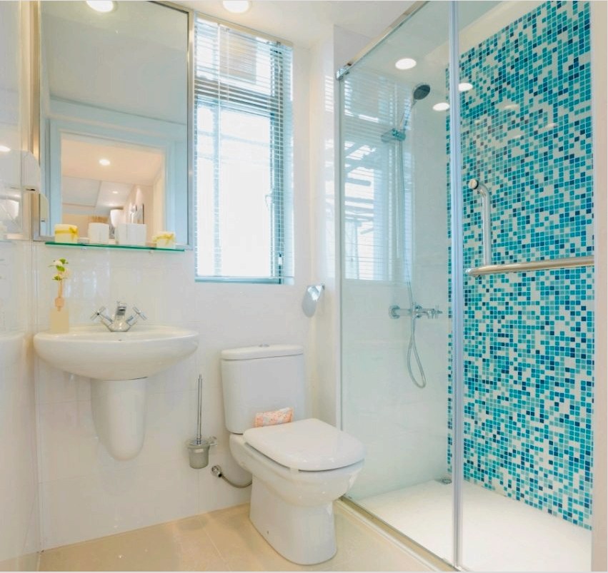 A fürdőszoba zuhanyzófénye világos mozaiklapokkal van bélelt.