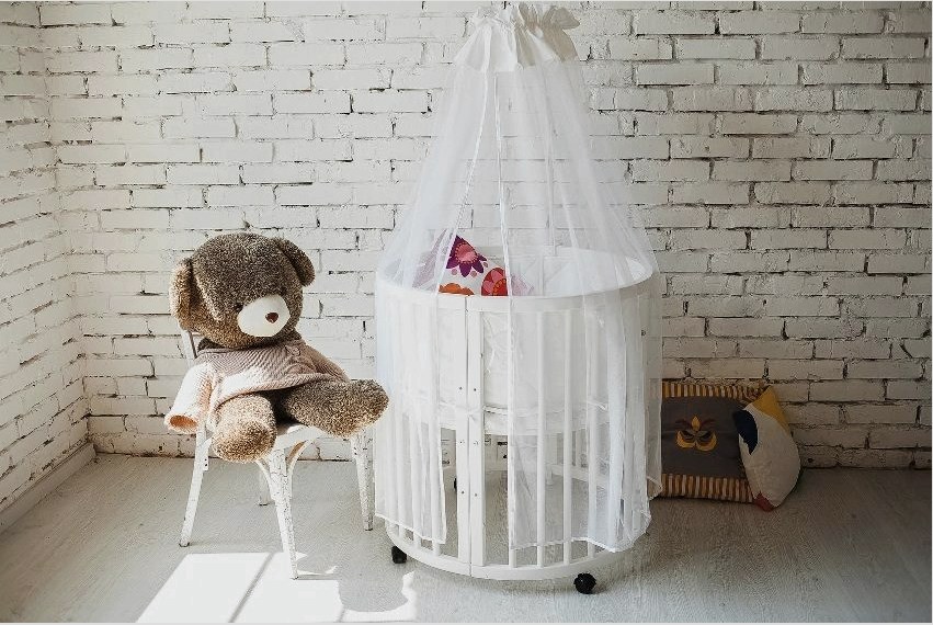 A baba szobájában van egy kerek ágynemű függönyökkel.