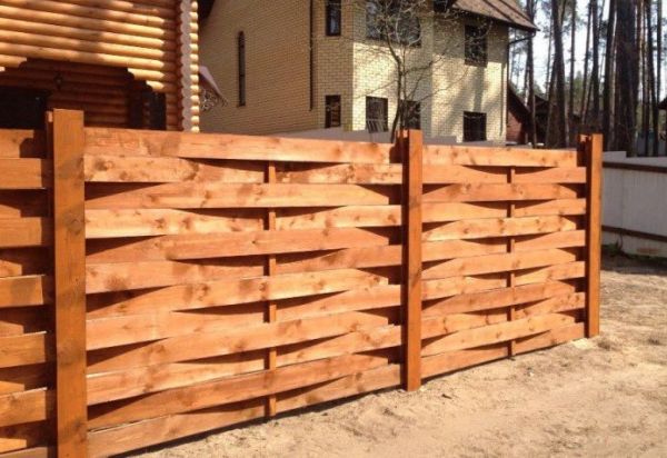 A deszkákból készült kerítés: különféle lehetőségek és barkács építés
