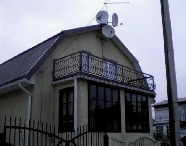 Erkély a tégla ház verandája felett. Erkély a ház tetején saját kezűleg